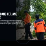 Petugas BPBD Tanggamus saat melakukan pemeriksaan luapan sungai Way Belu, Kota Agung Barat, Tanggamus, Selasa 22 September 2026.